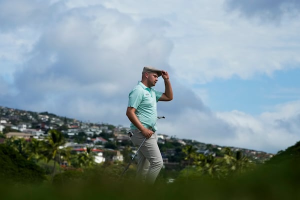 Harry Hall, of England, tips his hat after birdieing the 18th hole during the first round of the Sony Open golf event, Thursday, Jan. 9, 2025, at Waialae Country Club in Honolulu. (AP Photo/Matt York)