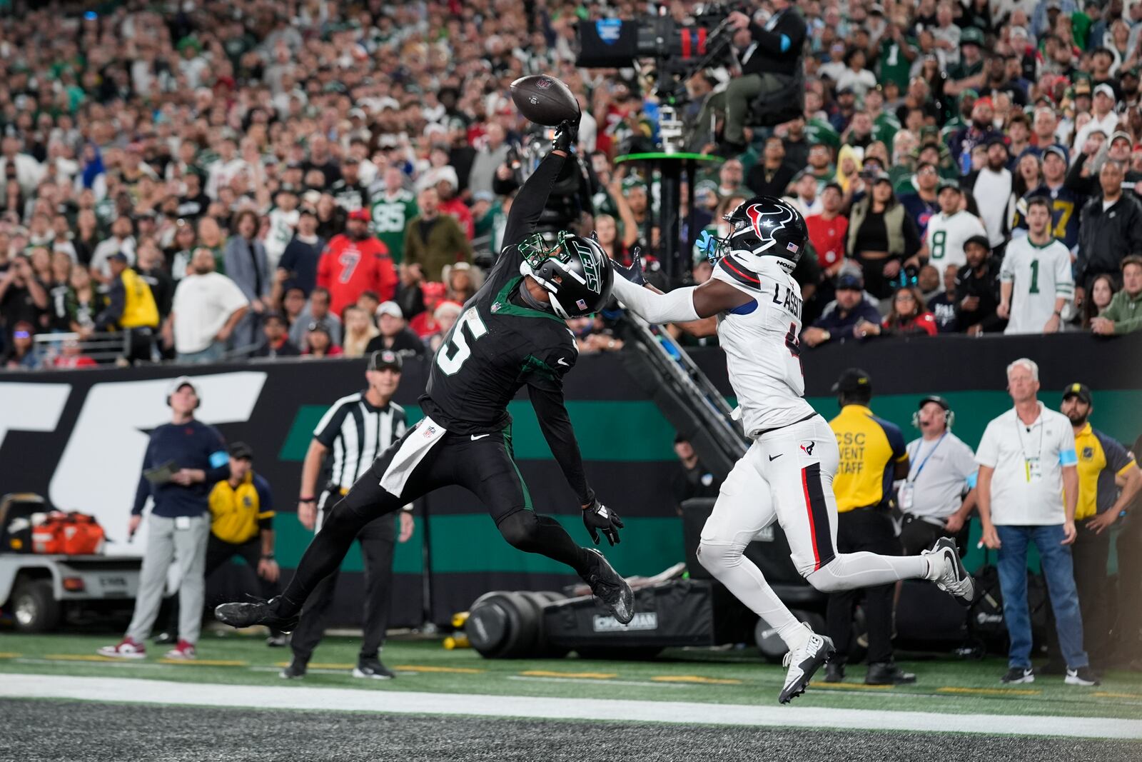 New York Jets wide receiver Garrett Wilson (5) catches a pass for a touchdown as Houston Texans cornerback Kamari Lassiter (4) defends during the second half of an NFL football game Thursday, Oct. 31, 2024, in East Rutherford, N.J. (AP Photo/Seth Wenig)