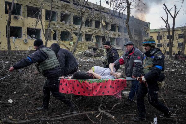 FILE - Ukrainian emergency employees and volunteers carry an injured pregnant woman from a maternity hospital damaged by shelling in Mariupol, Ukraine, Wednesday, March 9, 2022. (AP Photo/Evgeniy Maloletka, File)