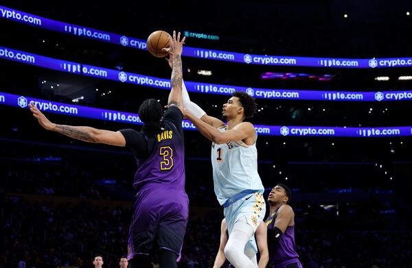 San Antonio Spurs center Victor Wembanyama (1) makes a layup against Los Angeles Lakers forward Anthony Davis (3) during the first quarter of an NBA basketball game Monday, Jan. 13, 2025, in Los Angeles. (AP Photo/Kevork Djansezian)