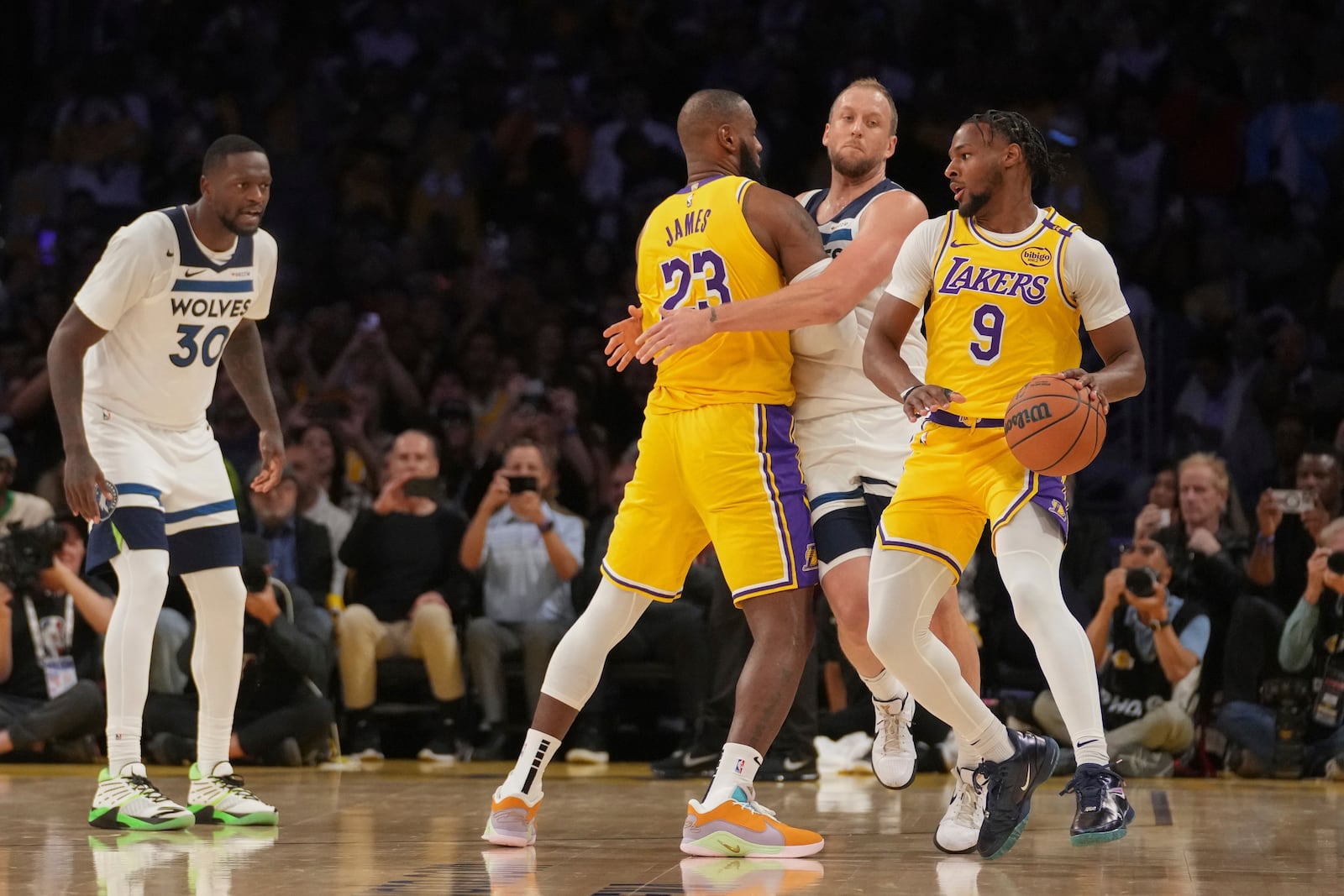 Los Angeles Lakers guard Bronny James (9) handles the ball during the first half of an NBA basketball game against the Minnesota Timberwolves, Tuesday, Oct. 22, 2024, in Los Angeles. (AP Photo/Eric Thayer)