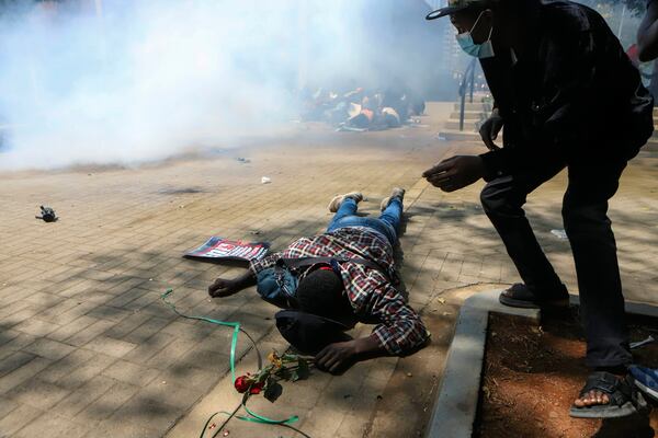 A man lies down on the ground after being tear-gassed by police during a protests against abductions dubbed "End Protests" in Nairobi, Kenya, Monday, Dec. 30, 2024. (AP Photo/Andrew Kasuku)