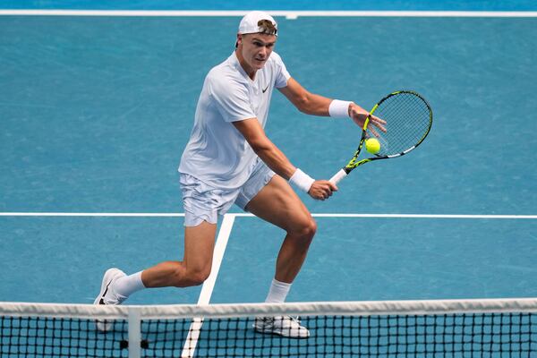 Holger Rune of Denmark plays a backhand return to Jannik Sinner of Italy during their fourth round match at the Australian Open tennis championship in Melbourne, Australia, Monday, Jan. 20, 2025. (AP Photo/Vincent Thian)