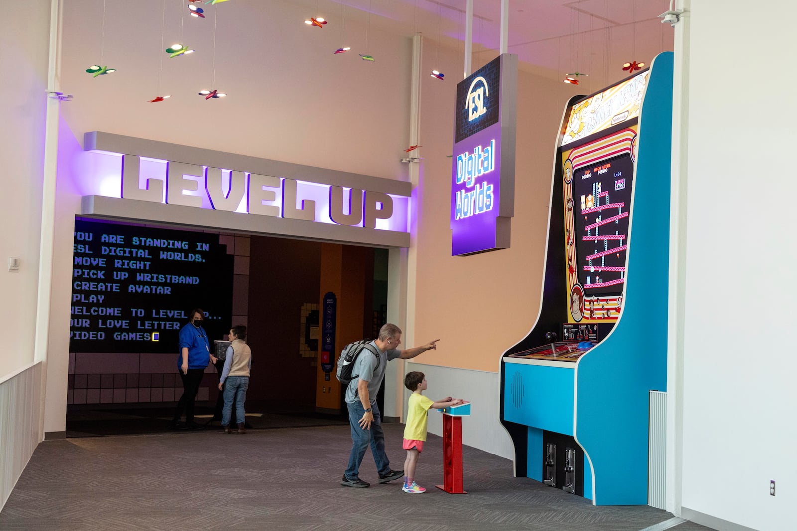 Travis Skadberg watches as Jacob, 6, plays a giant game of Donkey Kong at The Strong National Museum of Play, Tuesday, Oct. 15, 2024, in Rochester, N.Y. (AP Photo/Lauren Petracca)