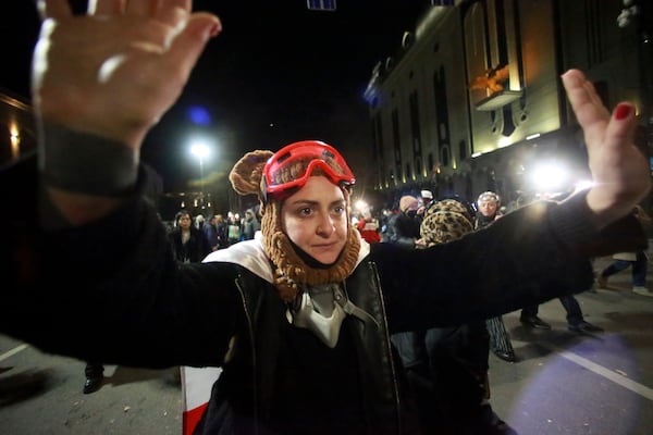 A young woman gestures as police use a water cannon to prevent protesters pouring into the streets following Georgian Prime Minister Irakli Kobakhidze's announcement, rallying outside the parliament building in Tbilisi, Georgia, Friday, Nov. 29, 2024. (AP Photo/Zurab Tsertsvadze)