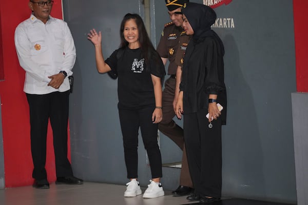 Filipino death row inmate Mary Jane Veloso, center, waves to the media as she leaves Pondok Bambu Prison for Soekarno-Hatta International Airport in preparation for her repatriation to the Philippines, in Jakarta, Indonesia, Tuesday, Dec. 17, 2024. (AP Photo/Achmad Ibrahim)