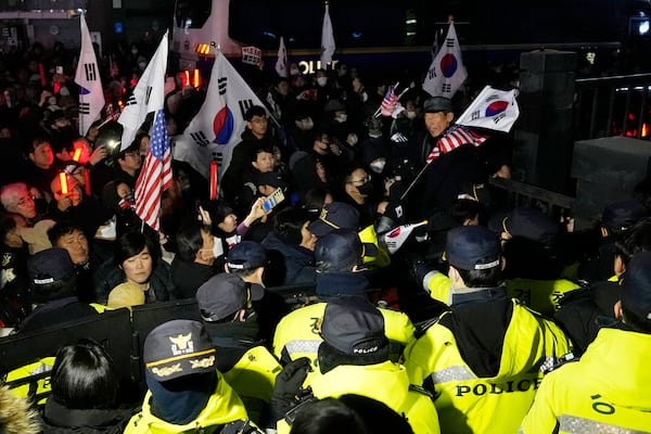 Police officers stand guard as supporters of impeached South Korean President Yoon Suk Yeol try to enter the Seoul Western District Court in Seoul, South Korea, Saturday, Jan. 18, 2025. (AP Photo/Ahn Young-joon)