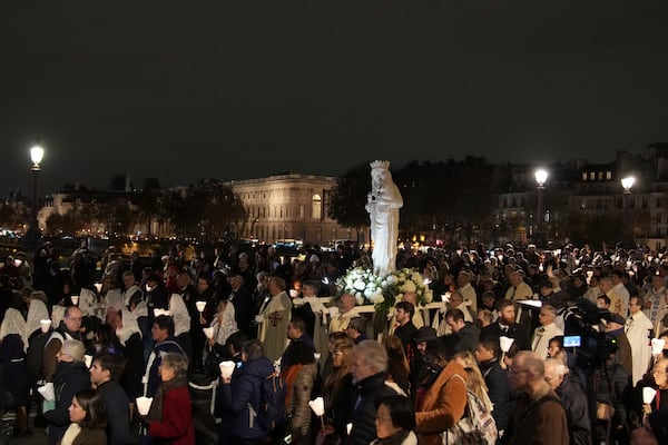 during a procession to bring the Virgin Mary statue from Saint-Germain l'Auxerrois church to Notre-Dame cathedral, Friday, Nov. 15, 2024 in Paris. (AP Photo/Christophe Ena)