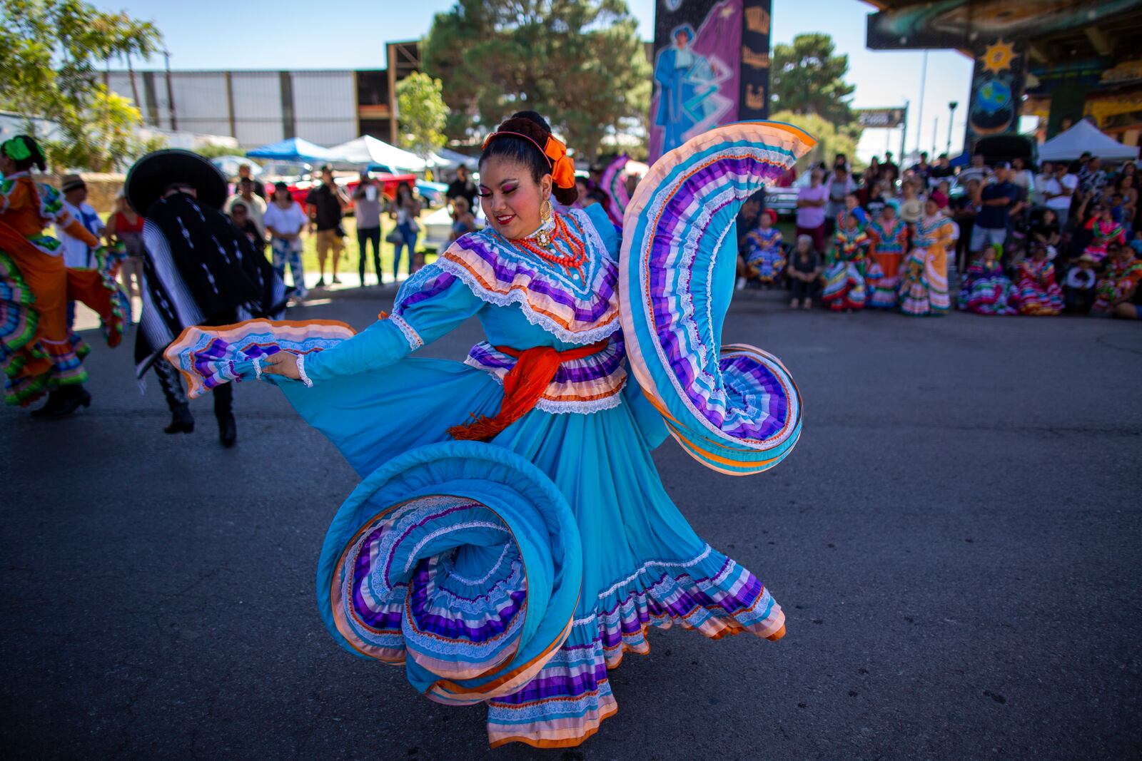 A folklorico ballet dancer performs during a lowrider exhibition for the 20th anniversary of Lincoln Park in El Paso, Texas, Sunday, Sept. 22, 2024. (AP Photo/Andrés Leighton)