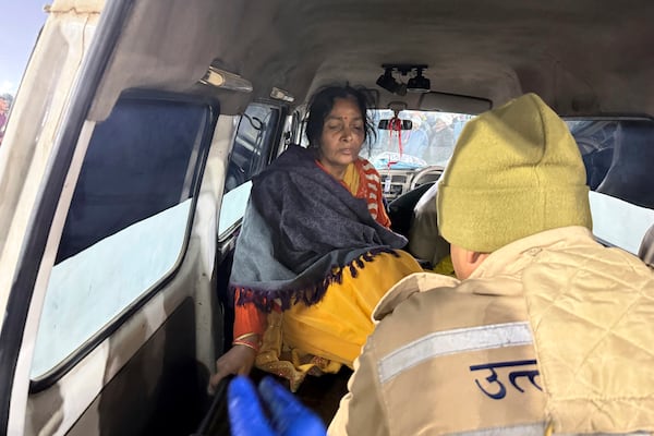 A woman injured in a stampede is helped into an ambulance by the banks of the Sangam, the confluence of the Ganges, the Yamuna and the mythical Saraswati rivers, on Mauni Amavasya' or new moon day during the Maha Kumbh festival, in Prayagraj, Uttar Pradesh, India, Wednesday, Jan. 29, 2025. (AP Photo/Rajesh Kumar Singh)