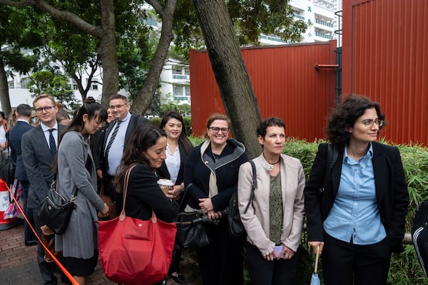 Representatives from various consulates wait in line outside the West Kowloon Magistrates' Courts in Hong Kong Tuesday, Nov. 19, 2024, ahead of the sentencing in national security case. (AP Photo/Chan Long Hei)