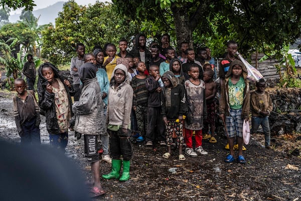 Congolese children watch the deployment of government and UN troops outside Goma, Democratic Republic of the Congo, Friday, Jan. 24, 2025, as M23 rebels are reported to close in on the town. (AP Photo/Moses Sawasawa)