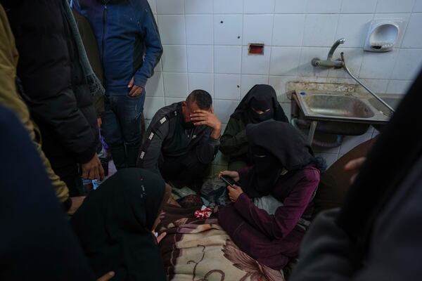 Relatives react next to the body of a Palestinian who was killed in the Israeli bombardment of the Gaza Strip at Al-Aqsa Hospital in Deir al-Balah, Wednesday, Jan. 15, 2025. (AP Photo/Abdel Kareem Hana)