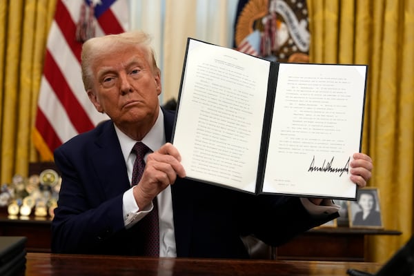 President Donald Trump signs an executive order relating to cryptocurrency in the Oval Office of the White House, Thursday, Jan. 23, 2025, in Washington. (AP Photo/Ben Curtis)