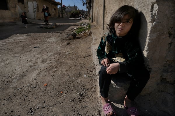 A Syrian girl sits next of her parent house, at an alley that was hit by the sarin struck during a 2013 chemical weapons attack that was blamed on then President Bashar Assad's forces, in Zamalka neighbourhood, on the outskirts of Damascus, Syria, Wednesday, Dec. 25, 2024. (AP Photo/Hussein Malla)