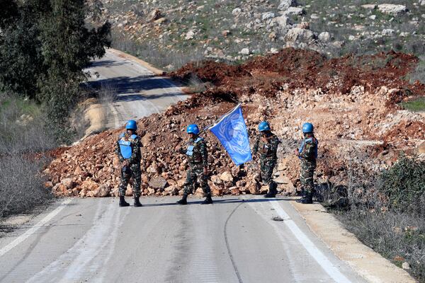 U.N peacekeepers hold their flag in Blida, a Lebanese border village with Israel in south Lebanon, Saturday, Jan. 25, 2025. (AP Photo/Mohammed Zaatari)