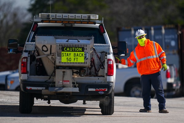 A worker is bundled up in near-freezing temperatures as he loads into a salt spreading truck at the Texas Department of Transportation Dallas Southwest lot as crews prepare the roads ahead of a winter storm expected to hit the North Texas region, Tuesday, Jan. 7, 2025, in Cedar Hill, Texas. (AP Photo/Julio Cortez)