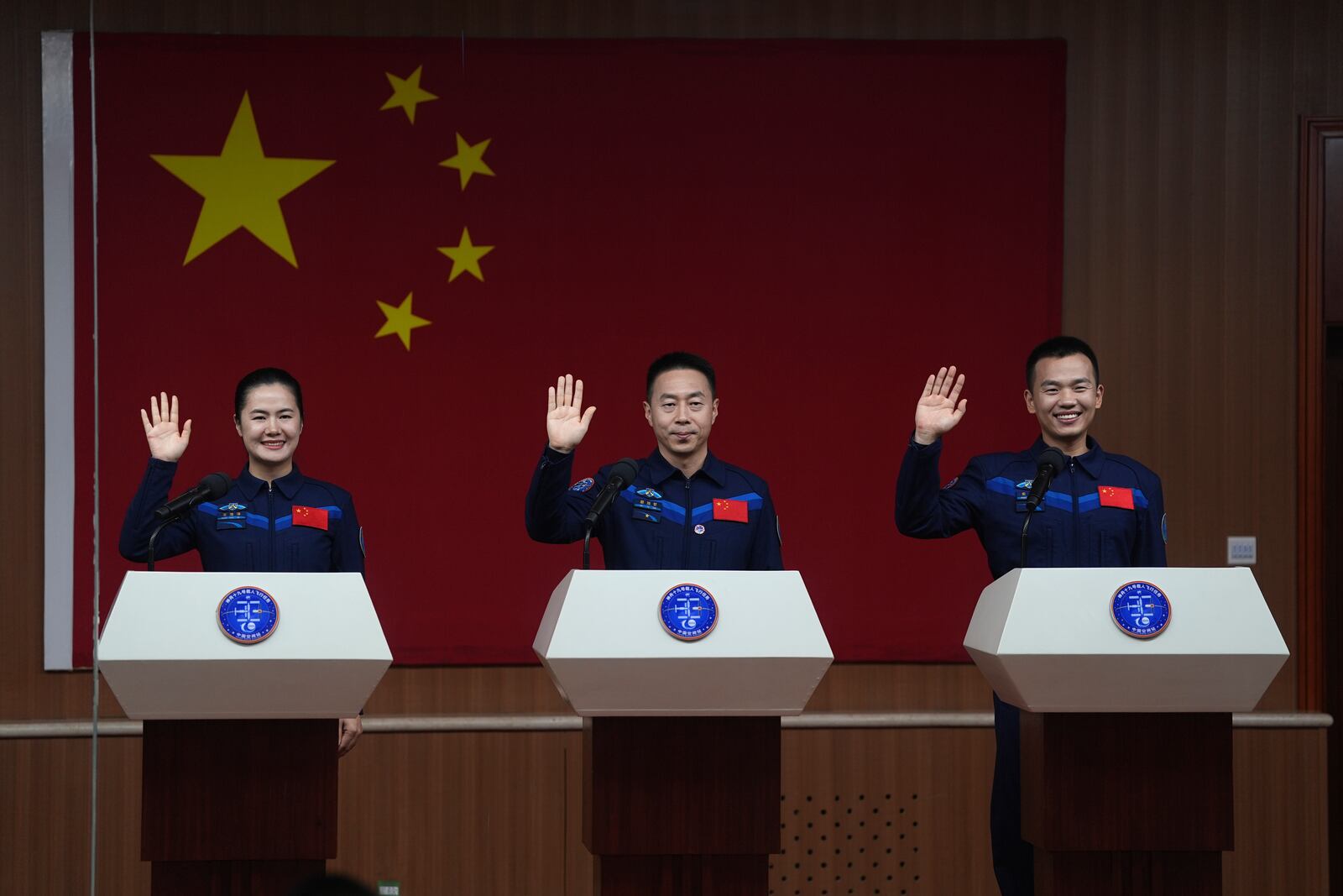 From left, Chinese astronauts Wang Haoze, Cai Xuzhe and Song Lingdong wave as they meet the press ahead of the Shenzhou-19 mission at the Jiuquan Satellite Launch Center in Jiuquan, northwestern China Tuesday, Oct. 29, 2024. (AP Photo/Ng Han Guan)