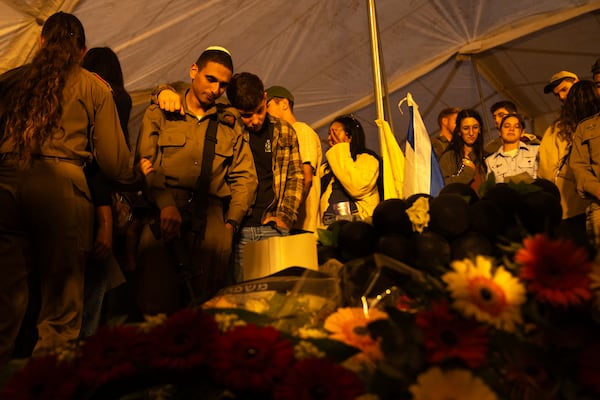 Israeli soldiers and relatives mourn during the funeral of captain Yogev Pazi, who was killed in Gaza, at the cemetery of Giv'ot Bar, southern Israel, Monday, Nov. 18, 2024. (AP Photo/Francisco Seco)