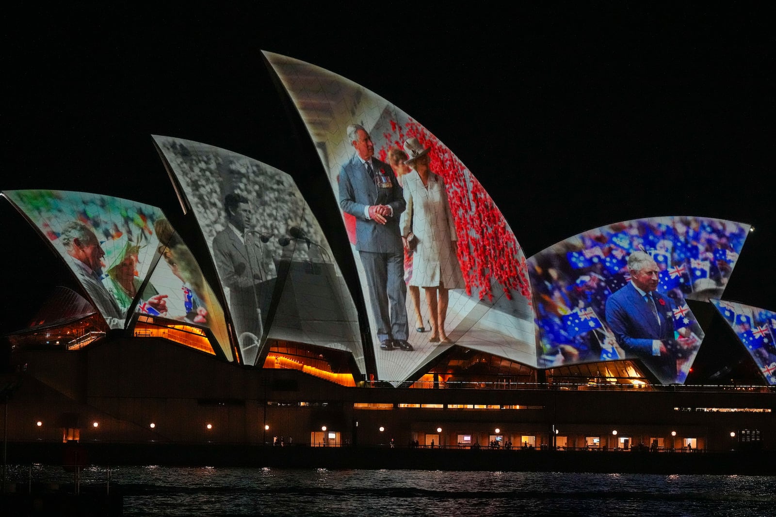 The Sydney Opera House sails show photos of Britain's King Charles and Queen Camilla soon after their arrival in Sydney, Australia, Friday, Oct. 18, 2024. (AP Photo/Mark Baker)