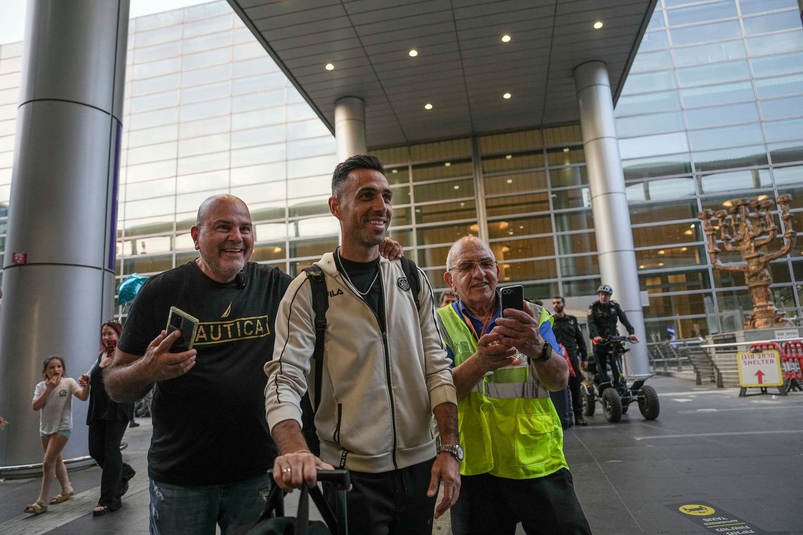 Eran Zahavi of Maccabi Tel Aviv, center, arrives at Israel's Ben-Gurion International Airport on a flight from Amsterdam, where Israeli soccer fans were attacked following a match between the Israeli club and Ajax Amsterdam, in Lod, Israel, Friday, Nov. 8, 2024. (AP Photo/Tsafrir Abayov)