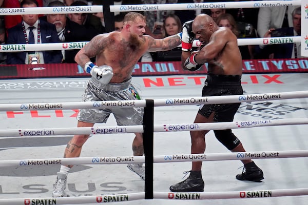 Jake Paul hits Mike Tyson during their heavyweight boxing match, Friday, Nov. 15, 2024, in Arlington, Texas. (AP Photo/Julio Cortez)