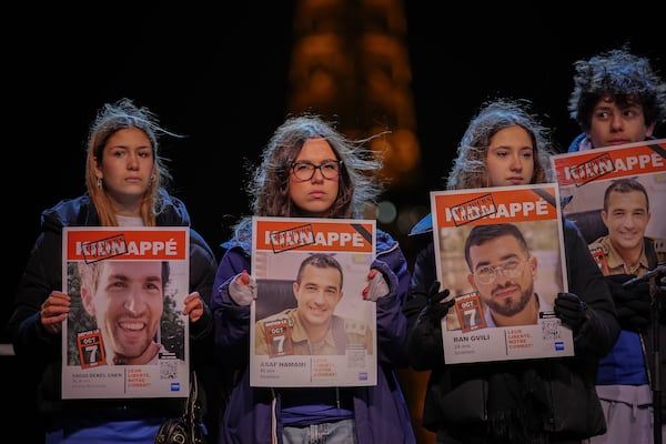 People hold hostages' portraits on stage during a rally in support to the hostages held in the Gaza Strip since Hamas' Oct. 7, 2023 attack on Israel, in Paris, France, Saturday, Sept. 18, 2025. (AP Photo/Aurelien Morissard)