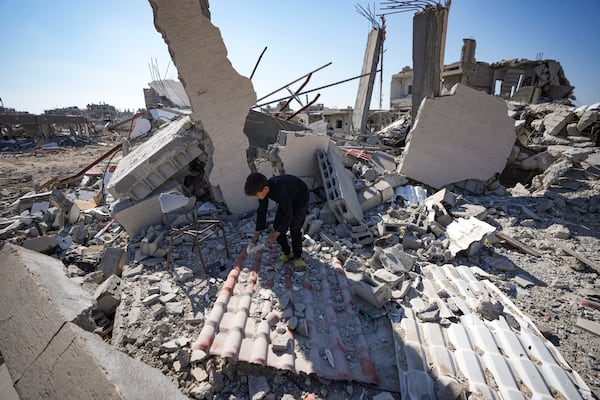 Youssef Muqdad salvages items from under the rubble of his destroyed family home, in Rafah, southern Gaza Strip, Tuesday, Jan. 21, 2025, days after the ceasefire deal between Israel and Hamas came into effect. (AP Photo/Abdel Kareem Hana)