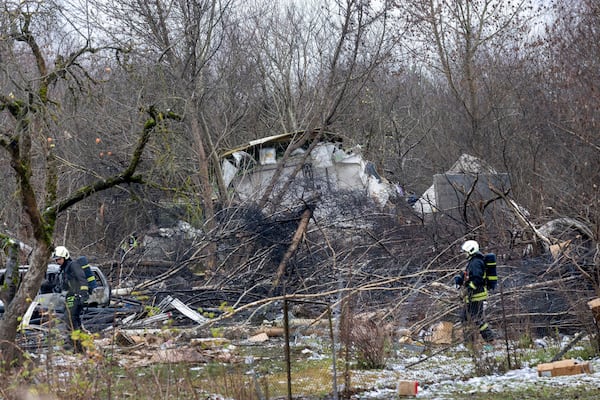 Lithuanian Emergency Ministry employees work near the site where a DHL cargo plane crashed into a house near the Lithuanian capital Vilnius, Lithuania, Lithuania, Monday, Nov. 25, 2024. (AP Photo/Mindaugas Kulbis)