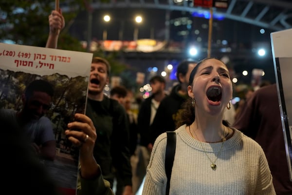 Relatives and friends of people killed and abducted by Hamas and taken into Gaza, react to the ceasefire announcement as they take part in a demonstration in Tel Aviv, Israel, Wednesday, Jan. 15, 2025. (AP Photo/Ohad Zwigenberg)