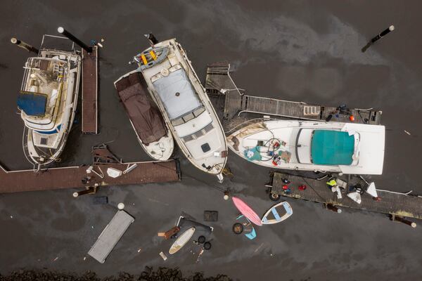 People pump water out of a boat in Santa Cruz Harbor in Santa Cruz, Calif., Tuesday, Dec. 24, 2024. (AP Photo/Nic Coury)