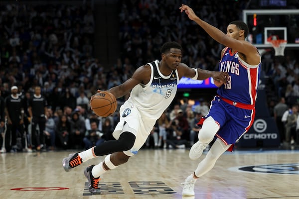 Minnesota Timberwolves guard Anthony Edwards (5) dribbles around Sacramento Kings forward Keegan Murray (13) during the second half of an NBA basketball game, Wednesday, Nov. 27, 2024, in Minneapolis. (AP Photo/Ellen Schmidt)