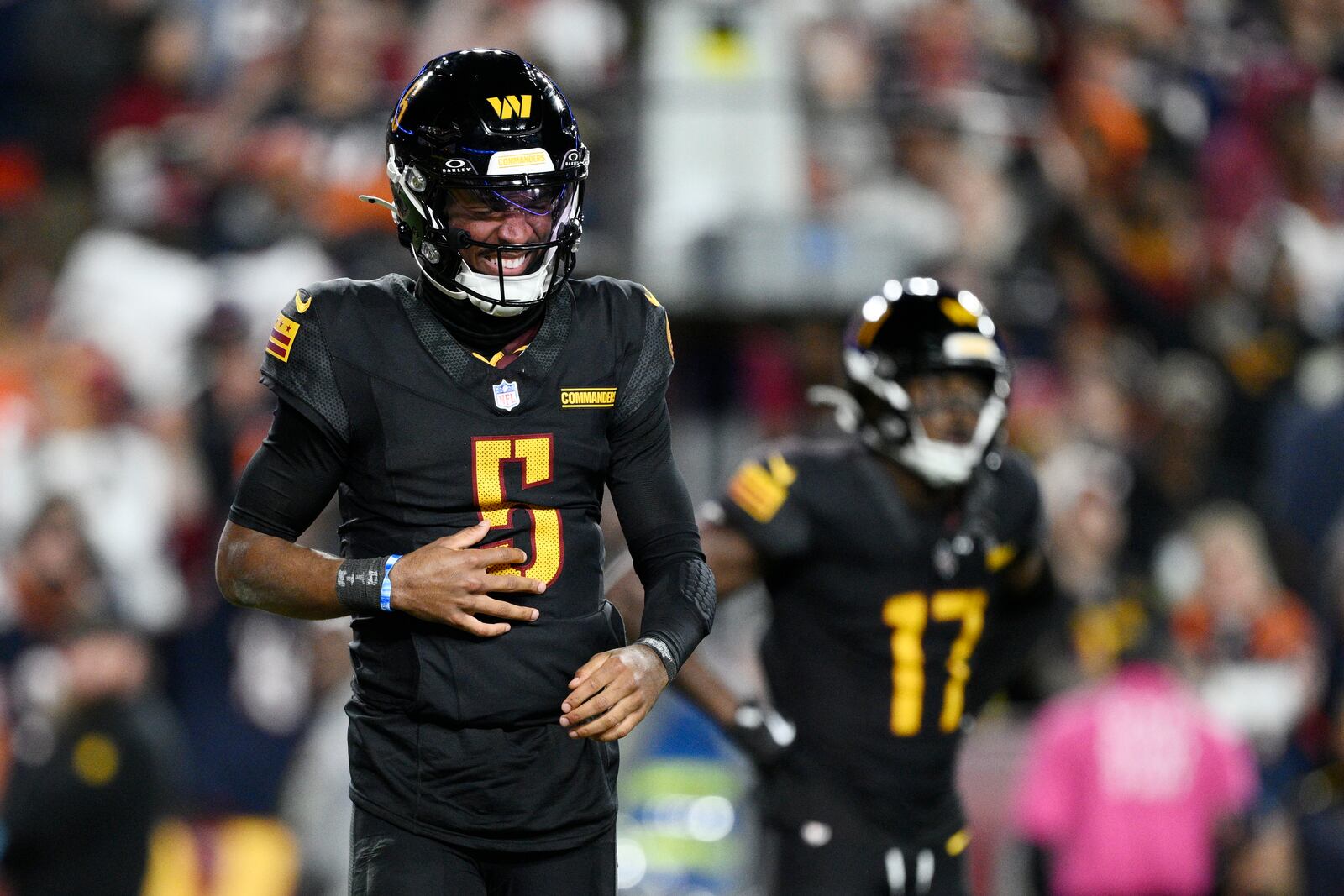 Washington Commanders quarterback Jayden Daniels (5) winces in pain after a play in the second half of an NFL football game against the Chicago Bears Sunday, Oct. 27, 2024, in Landover, Md. (AP Photo/Nick Wass)