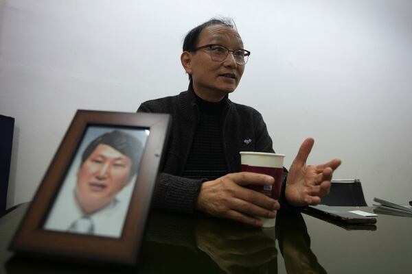 Kim Jeong-sam speaks during an interview next to his brother Kim Jung Wook's photo at his office in Incheon, South Korea, Friday, Nov. 29, 2024. (AP Photo/Lee Jin-man)