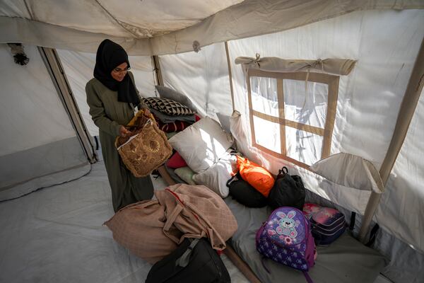 Majida Abu Jarad packs belongings as she prepares to go back to the family's home in the north, at a camp for displaced Palestinians in the Muwasi area, southern Gaza Strip, Saturday, Jan. 18, 2025. (AP Photo/Abdel Kareem Hana)