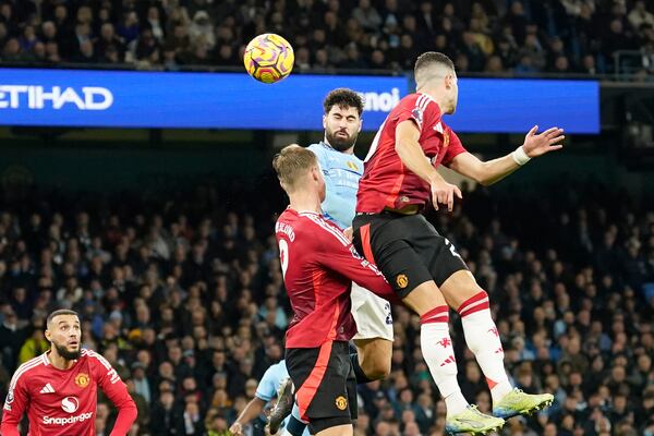 Manchester City's Josko Gvardiol, centre, scores his side's opening goal during the English Premier League soccer match between Manchester City and Manchester United at the Etihad Stadium in Manchester, Sunday, Dec. 15, 2024. (AP Photo/Dave Thompson)