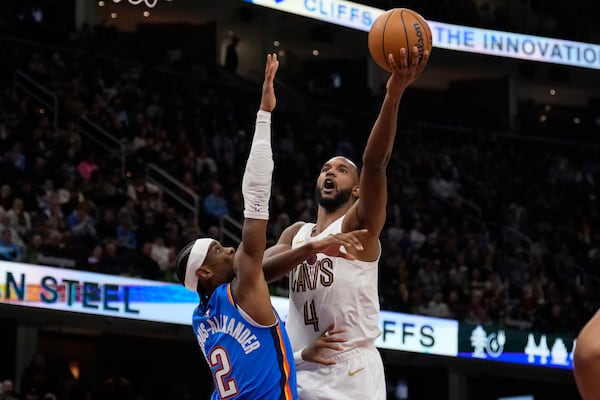 Cleveland Cavaliers forward Evan Mobley (4) shoots as Oklahoma City Thunder guard Shai Gilgeous-Alexander (2) defends in the first half of an NBA basketball game, Wednesday, Jan. 8, 2025, in Cleveland. (AP Photo/Sue Ogrocki)