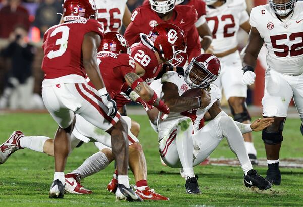 Alabama quarterback Jalen Milroe (4) is tackled by Oklahoma linebacker Danny Stutsman (28) during the second quarter of a NCAA college football game Saturday, Nov. 23, 2024, in Norman, Okla. (AP Photo/Alonzo Adams)