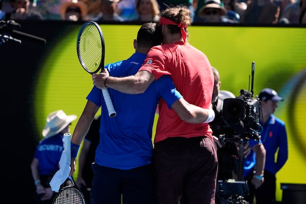 Alexander Zverev, right, of Germany embraces Novak Djokovic of Serbia after Djokovic retired in their semifinal match at the Australian Open tennis championship in Melbourne, Australia, Friday, Jan. 24, 2025. (AP Photo/Asanka Brendon Ratnayake)