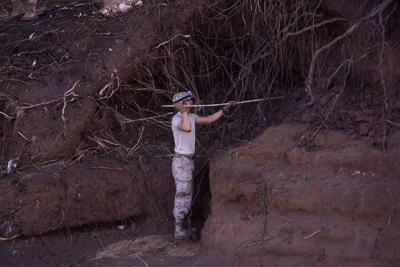 A soldier from the Spanish Parachute Squadron (EZAPAC) searches for bodies after floods in Barranco del Poyo on the outskirts of Valencia, Spain, Tuesday, Nov. 5, 2024. (AP Photo/Alberto Saiz)