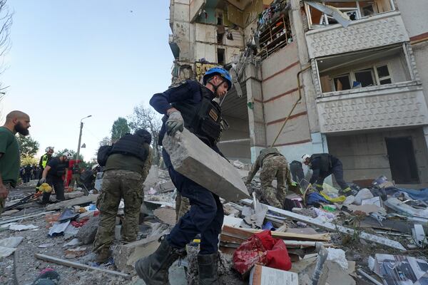 FILE - Emergency workers and soldiers try to shift the rubble and debris after a Russian attack that hit a residential building in Kharkiv, Ukraine, Tuesday Sept. 24, 2024. (AP Photo/Andrii Marienko, File)