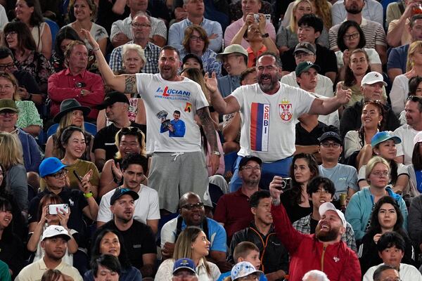 Supporters of Novak Djokovic of Serbia react during his quarterfinal match against Carlos Alcaraz of Spain at the Australian Open tennis championship in Melbourne, Australia, Tuesday, Jan. 21, 2025. (AP Photo/Ng Han Guan)