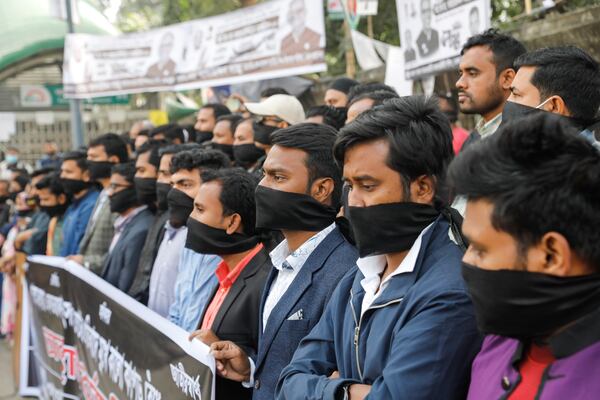 Activists of Gono Odhikar Parishad stand wearing black clothes on the face to protest against what they called a one sided election at the National Press Club in Dhaka, Bangladesh, Monday, Jan.8, 2024. Prime Minister Sheikh Hasina has won an overwhelming majority in Bangladesh's parliamentary election after a campaign fraught with violence and a boycott from the main opposition party, giving her and her Awami League a fourth consecutive term. (AP Photo/Mahmud Hossain Opu)