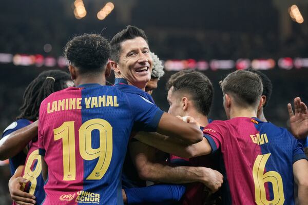 Barcelona's Robert Lewandowski, centre, celebrates after scoring his side's second goal during the Spain Super Cup final soccer match between Real Madrid and Barcelona at King Abdullah Stadium in Jeddah, Saudi Arabia, Sunday, Jan. 12, 2025. (AP Photo/Altaf Qadri)