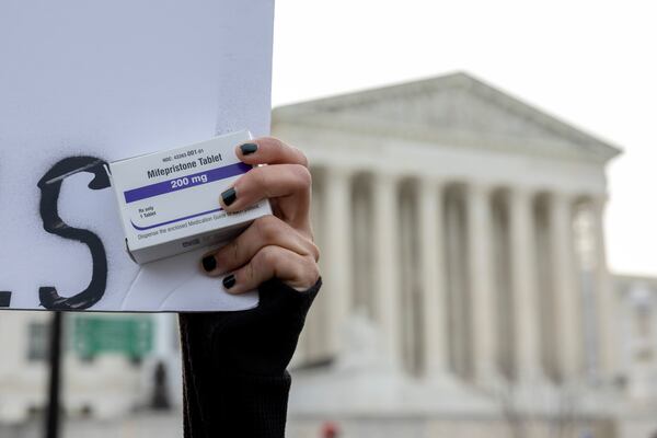 FILE - An abortion- rights activist holds a box of mifepristone pills as demonstrators from both anti-abortion and abortion-rights groups rally outside the Supreme Court in Washington, Tuesday, March 26, 2024. (AP Photo/Amanda Andrade-Rhoades, File)