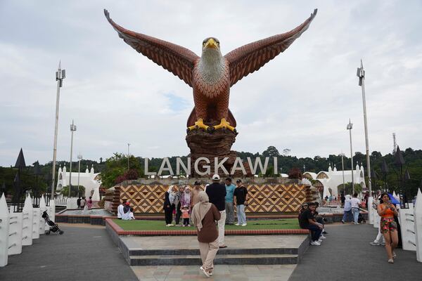 Tourists take pictures with a landmark eagle statue in Langkawi Island, Malaysia, on Saturday, January 18, 2025. (AP Photo/Azneal Ishak)