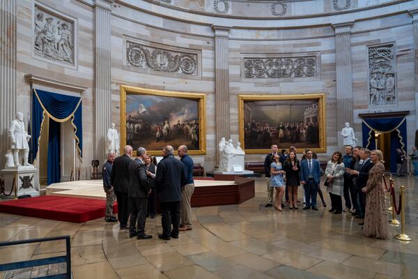 Officials and visitors observe near a stand in the Rotunda, where President-elect Donald Trump is due to take the oath of office on Monday, at the Capitol in Washington, Friday, Jan. 17, 2025. (AP Photo/Ben Curtis)