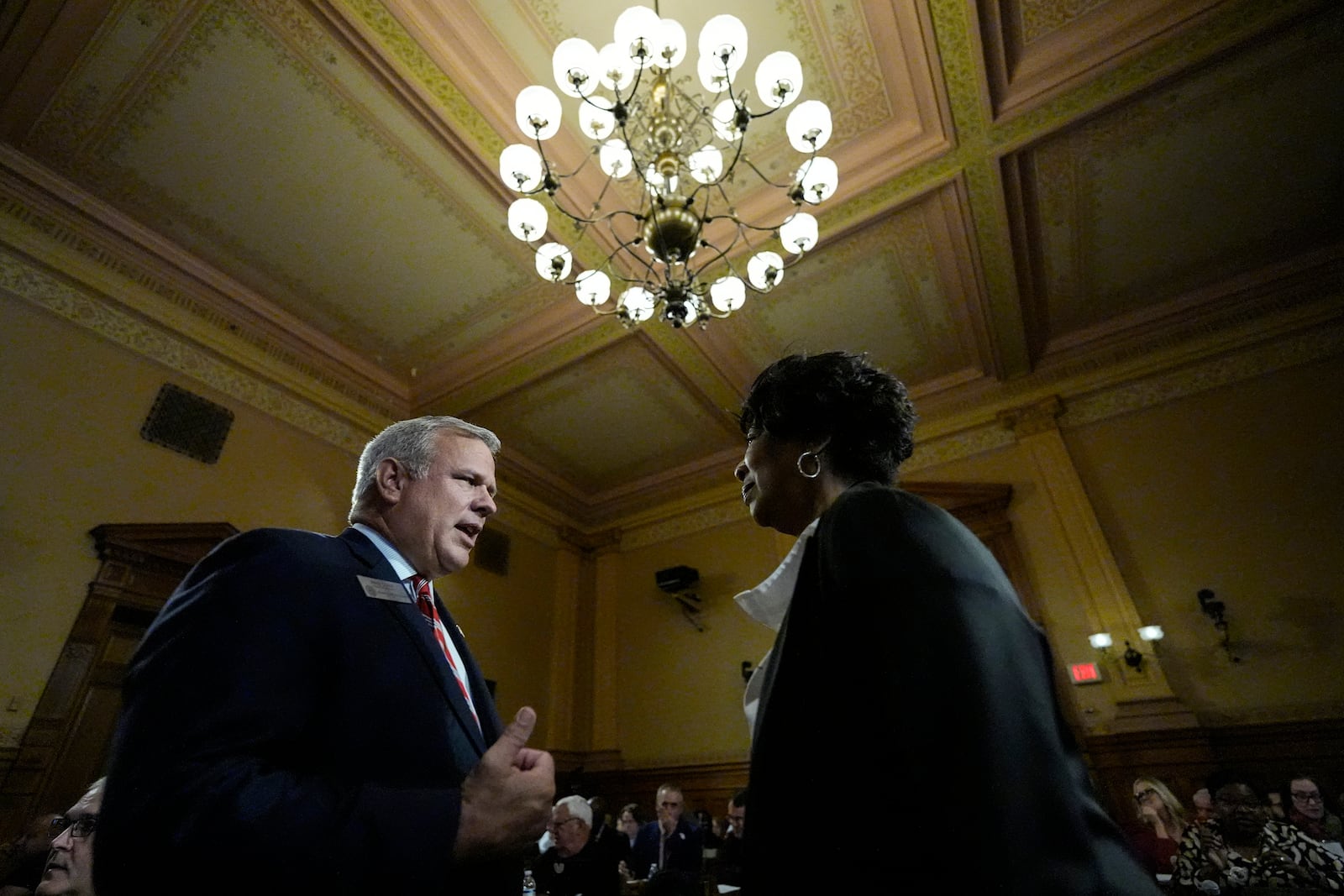 FILE - State board Executive Director Mike Coan speaks to Rep. Debra Bazemore ahead of a Georgia state election board meeting at the state capitol, Sept. 20, 2024, in Atlanta. (AP Photo/Mike Stewart, File)