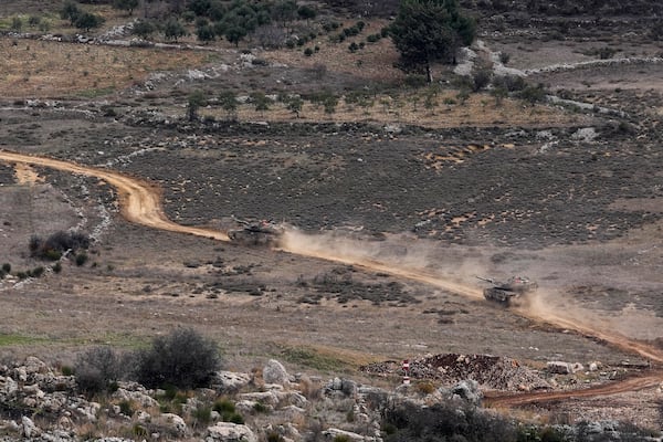 Israeli tanks cross the security fence moving towards the so-called Alpha Line that separates the Israeli-annexed Golan Heights from Syria, in the town of Majdal Shams, Wednesday, Dec. 11, 2024. (AP Photo/Matias Delacroix)