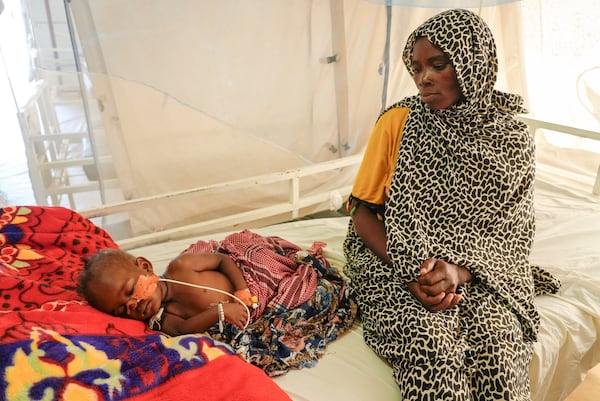 FILE - Sudanese Khadiga Omer adam sits by her sick child in an MSF-run clinic in the Aboutengue displacement site near Acre, Chad, Friday, Oct 4. 2024. (AP Photo/Sam Mednick, File)